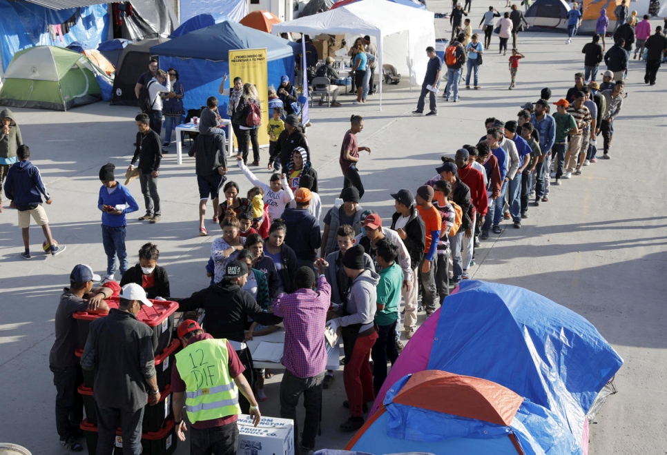 Des demandeurs d'asile dans une file d'attente lors d'une distribution de vivres dans le refuge El Barretal à Tijuana, Mexique. Décembre 2018. 