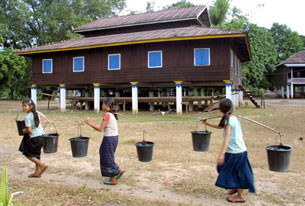 Three young Laotian girls carry water in a village in Khammouane province, Nov. 27, 2002.
