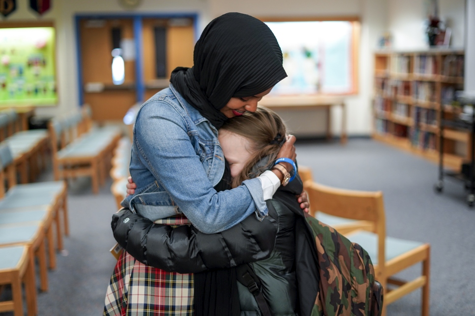 Una joven admiradora abraza a Habso Mohamud, ex refugiada somalí y autora de libros infantiles, después de leer su libro "It Only Takes One Yes".