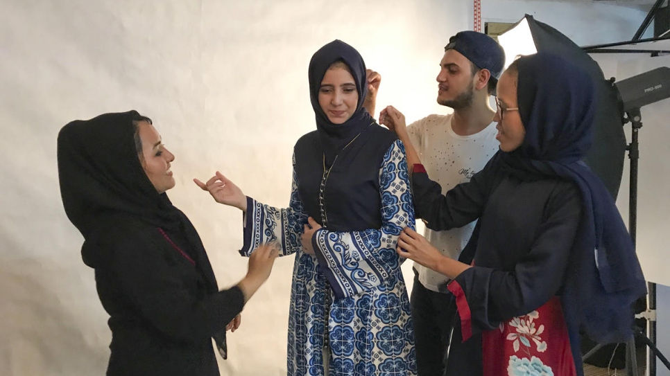 Franka Soeria (en foulard bleu marine) aide certains de ses étudiants en mode et réfugiés à faire des ajustements de dernière minute avant une séance photo dans son atelier Markamarie à Djakarta-Sud. 