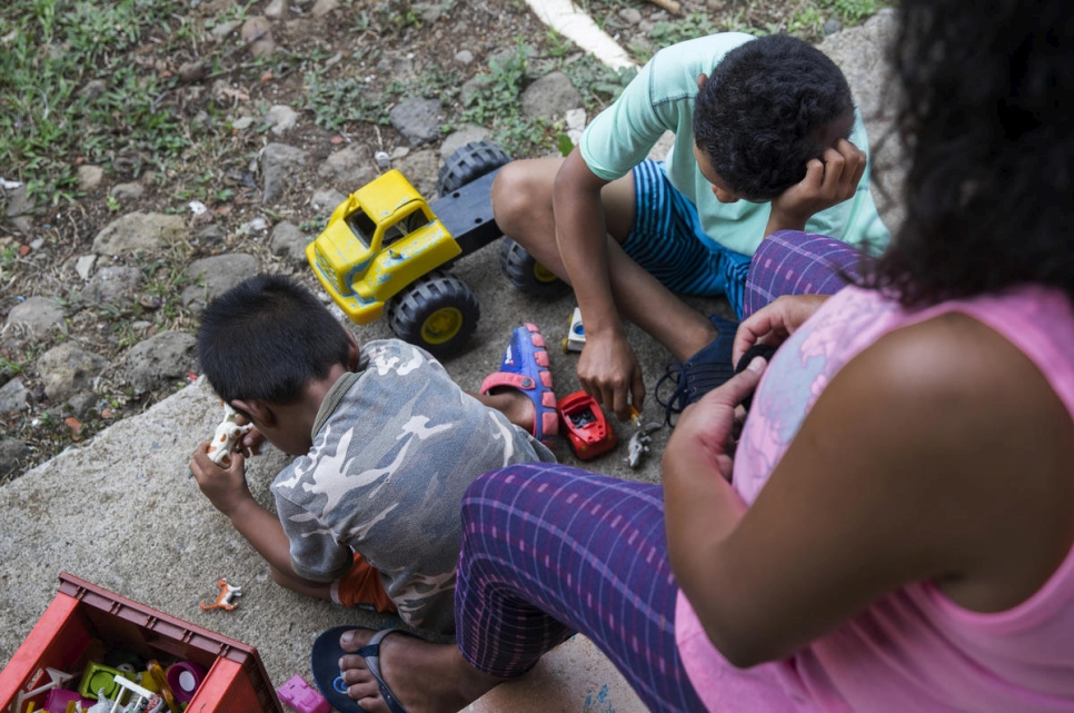 Andrea, demandeuse d'asile, nicaraguayenne et enceinte, avec ses deux enfants en train de jouer devant leur nouvelle maison au Costa Rica. 