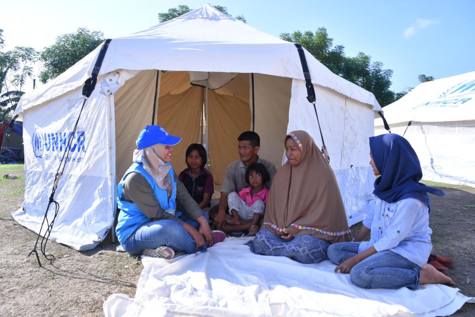 Une employée du HCR avec Bampek et sa famille qui ont survécu au séisme à Sulawesi. 