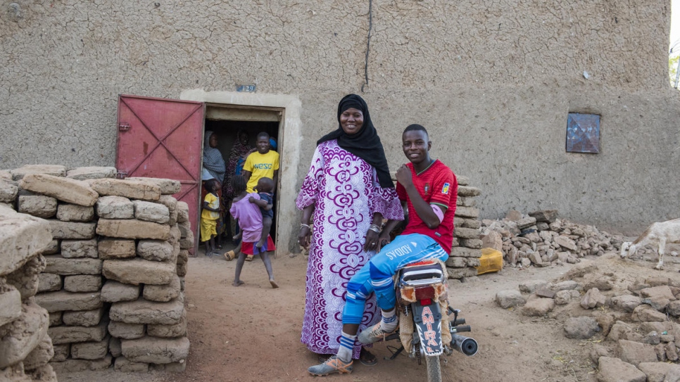 Djamila Amadou est devant sa maison, à Gao, avec son fils Omar, qui veut étudier l'informatique. 
