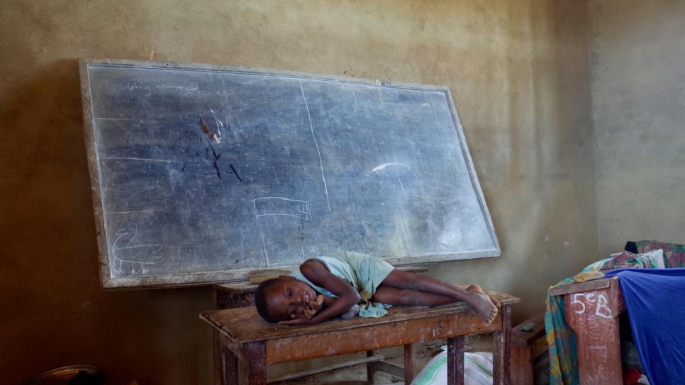 Rebecca, la fille d'Agnès, est allongée sur une table dans la salle de classe de l'école où elles vivent à Oicha, sur le territoire de Beni, dans la province du Nord-Kivu. 
