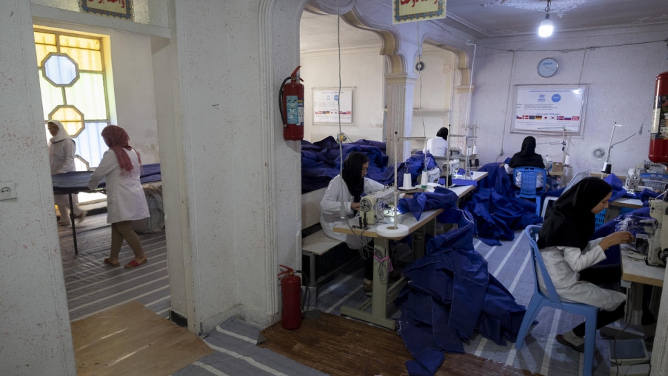Iranian and Afghan employees work at the tailoring workshop.