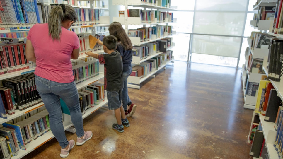 Claudia* and her children Samuel* and Maité* browse books at the Biblioparque library in Saltillo, Mexico.