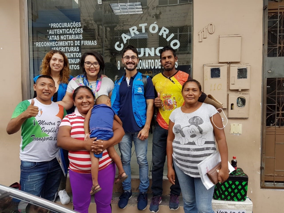 Norberto (a la derecha) celebra el inicio del proceso de revalidación de su diploma junto a trabajadores de ACNUR y Compassiva en Manaos. 