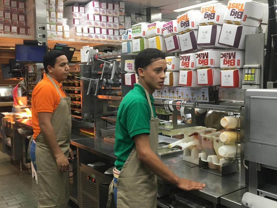 Jefferson, venezolano de 18 años (a la derecha), en el restaurante McDonald's donde está trabajando en São Paulo.