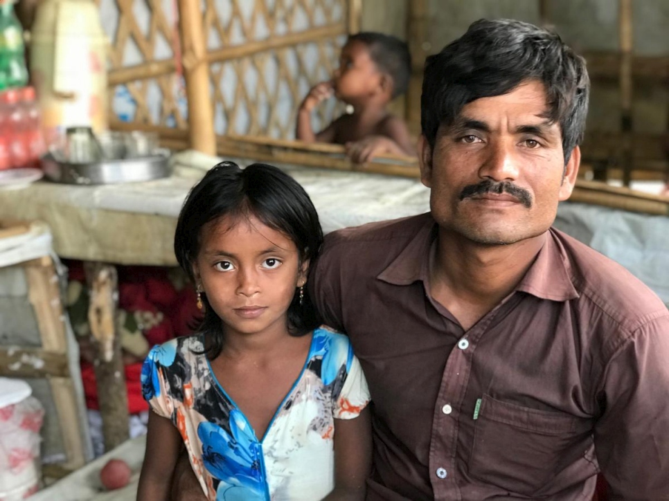 Nurul Salam, de 35 años, con su hija de 8 años, Janatara, en la tienda de té que gestiona en el asentamiento de refugiados de Kutupalong, en Bangladesh.