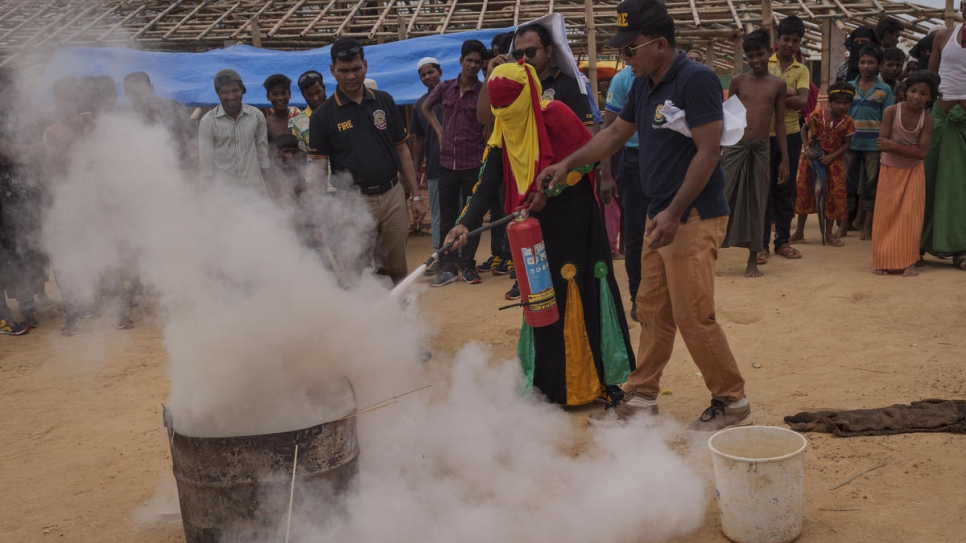 Ayesha, âgée de 25 ans, reçoit une formation en prévention des risques d'incendie donnée par les sapeurs-pompiers du Bangladesh dans le camp de réfugiés de Kutupalong, où elle vit depuis sept mois et la mort de son mari, tué au Myanmar. 