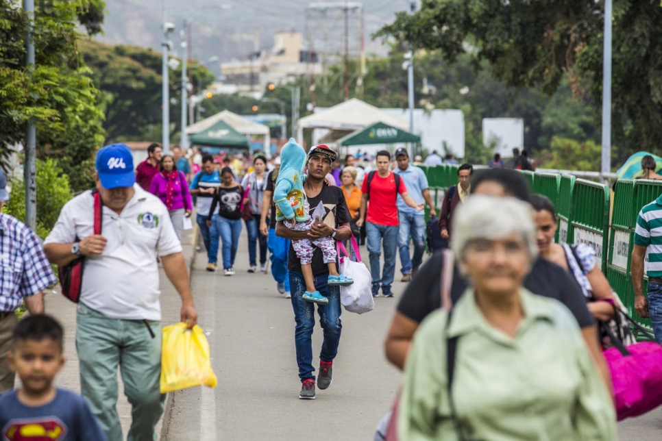 Un padre camina hacia Colombia a través del puente Simón Bolívar tras haber salido de Venezuela.