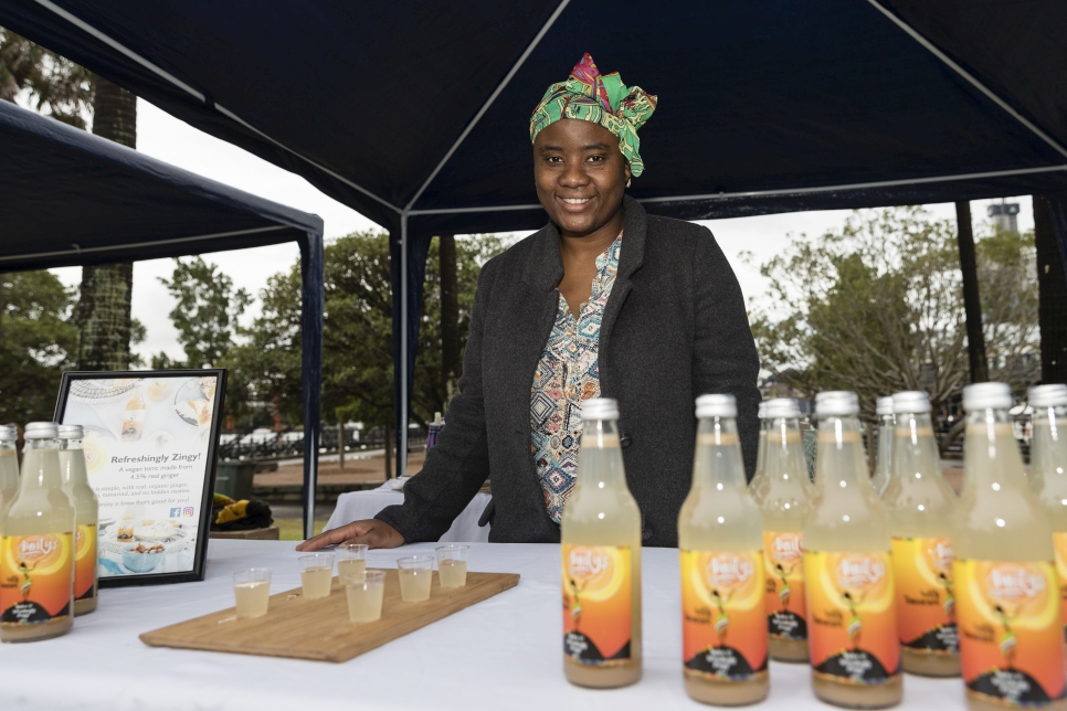 Yarrie Bangura sells Aunty's Ginger Tonic as Australians walk together with their neighbours from refugee backgrounds around Sydney harbour to celebrate World Refugee Day.