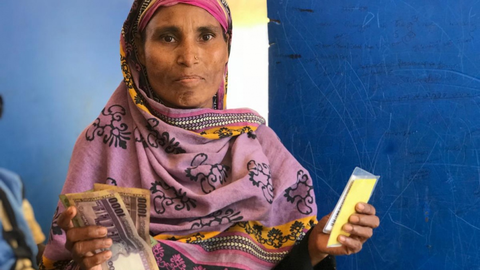 Samuda, 35 ans, réfugié rohingya et chef de famille monoparentale, reçoit une aide financière de la part du HCR au Bangladesh, en avril 2018. Elle dit : « La première chose que je vais faire, c'est rembourser nos dettes et ensuite nous utiliserons cet argent pour acheter de la nourriture ». 