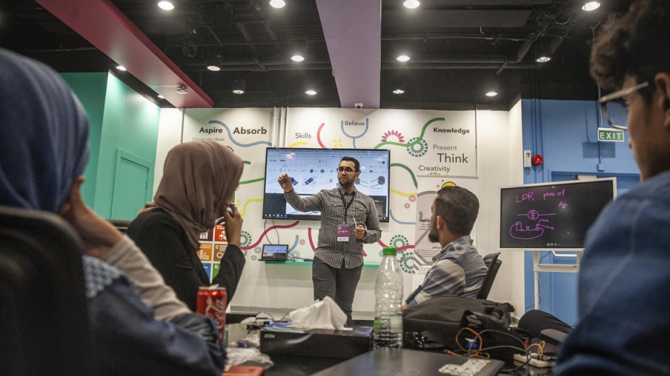 Students listen on as Ehab explains how the remote sensing technology his company markets can be used. 