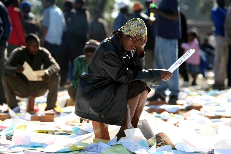 Des réfugiés récupèrent des documents dans un centre d'hébergement à Johannesburg, en Afrique du Sud. Août 2008. 