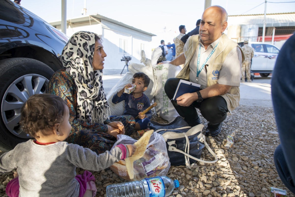Un employé du HCR en charge de la protection s'entretient avec des réfugiés syriens nouvellement arrivés au camp de réfugiés de Domiz, dans la région du Kurdistan irakien.