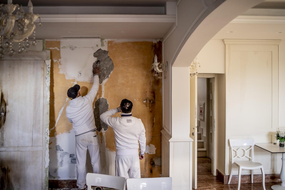 Roberto (à gauche) et Silvio sont en train de plâtrer un mur à l'hôtel Villa Perast. 
