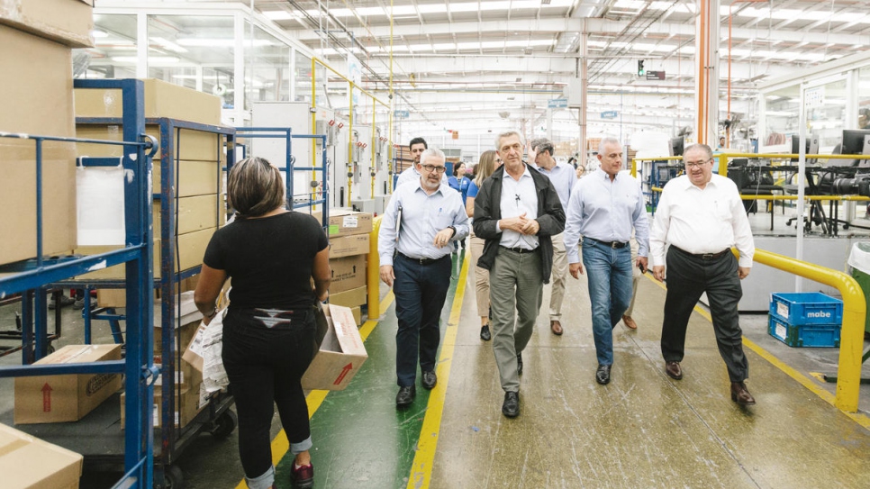 Filippo Grandi (au centre) visite l'usine de production de Mabe à Saltillo, au Mexique. L'usine emploie des réfugiés réinstallés pour fabriquer des appareils électroménagers qui seront distribués dans le monde entier. 
