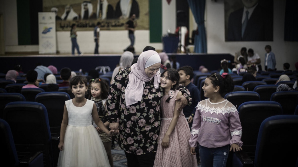 Abir Khreisha est entourée de jeunes réfugiés syriens lors d'un événement dans un centre communautaire à Madaba, en Jordanie. 