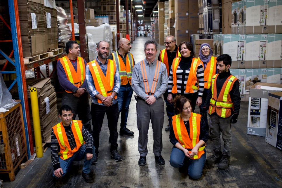 Jim Estill, PDG de 'Danby Appliance' (au centre), avec des travailleurs syriens dans l'entrepôt de son entreprise au Canada.  