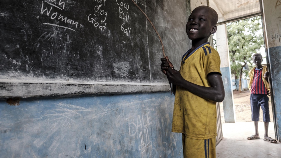Sourire d'un jeune réfugié sud-soudanais en train de montrer ce qu'il a appris à l'école primaire du camp de réfugiés de Jewi à Gambella, Éthiopie.