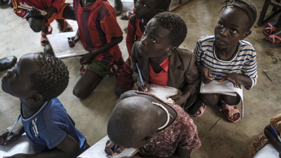 Des élèves réfugiés en train d'écrire dans leur cahier à l'école primaire du camp de réfugiés de Jewi à Gambella. Il n'y a jamais assez de manuels ou d'enseignants pour répondre à la demande d'éducation