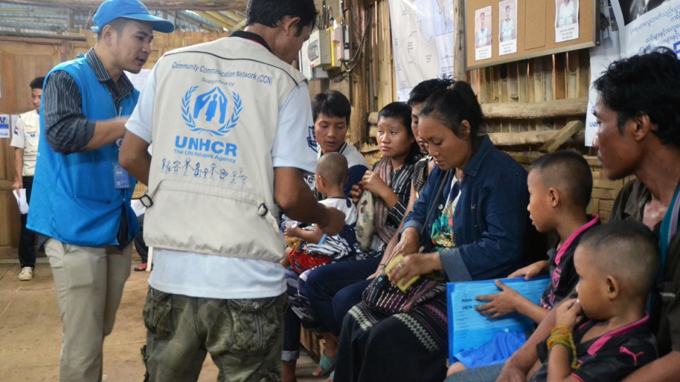 Les équipes du HCR en train de dispenser des informations de dernière minute aux familles réfugiées du Myanmar avant le départ du camp provisoire de Mae La, dans le district de Tha Song Yang, province de Tak, dans l'ouest de la Thaïlande.