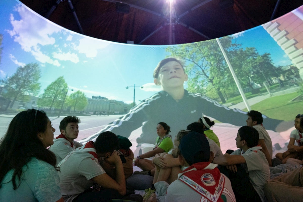 Des scouts regardent une vidéo à 360 degrés sur le réfugié syrien Omar au 24e Jamboree Scout Mondial en Virginie de l'Ouest. 