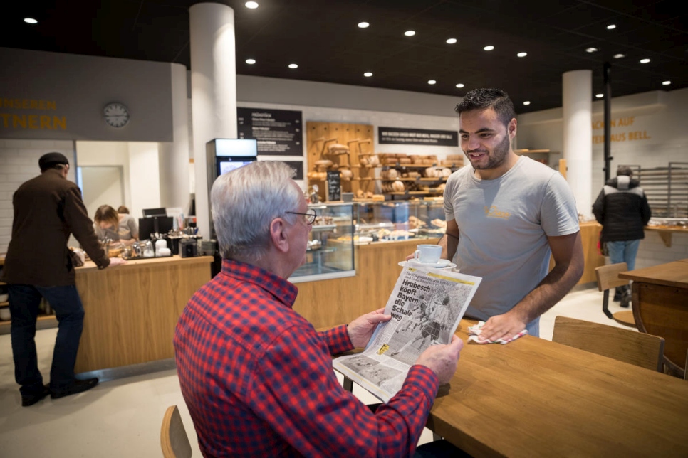 Mohamad practica su alemán con un cliente en la panadería. 