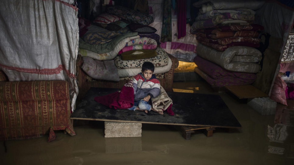 L'un des fils de Juriya Ramadan est assis dans l'abri familial inondé. La tente s'est effondrée lors du passage de la violente tempête Norma. 