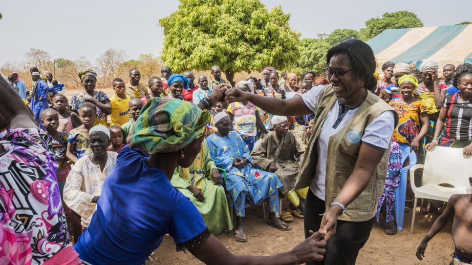 Rosine Zouassi, of the Côte d'Ivoire Women's Legal Aid Association, dances with a village resident at the end of a documentation outreach meeting in Olleo, Côte d'Ivoire.
