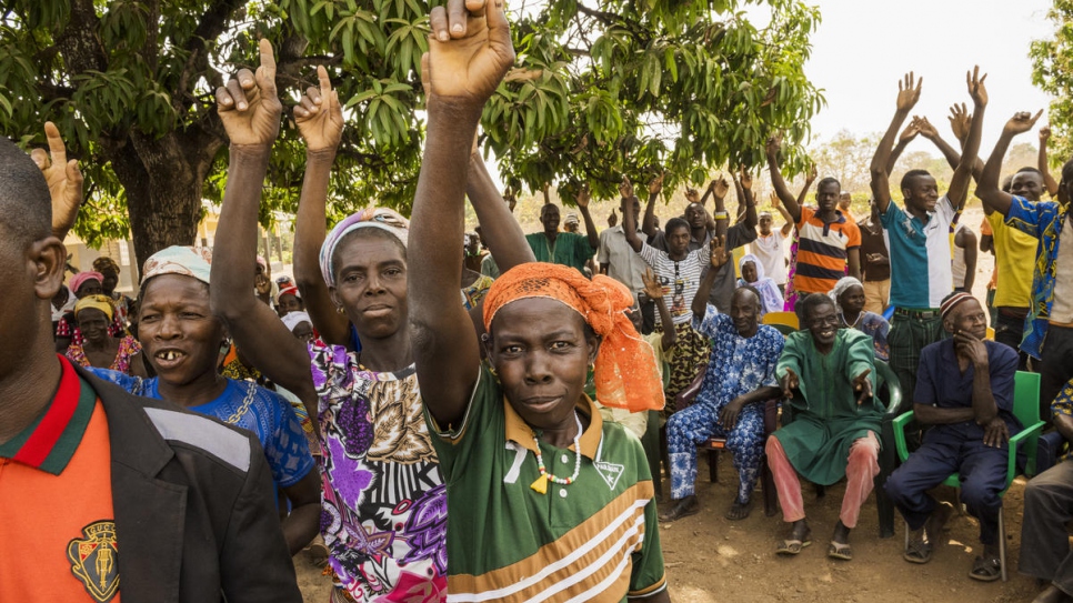 When asked to identify themselves if they are undocumented, village residents in Olleo, Côte d'Ivoire, raise their arms.
