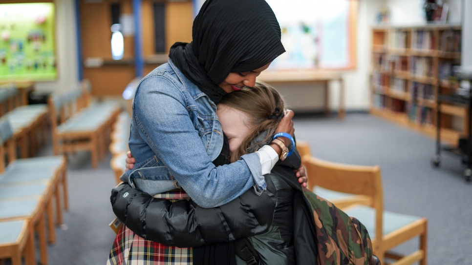 A young fan embraces former Somali refugee and children's book author Habso Mohamud after a reading of her book "It Only Takes One Yes."