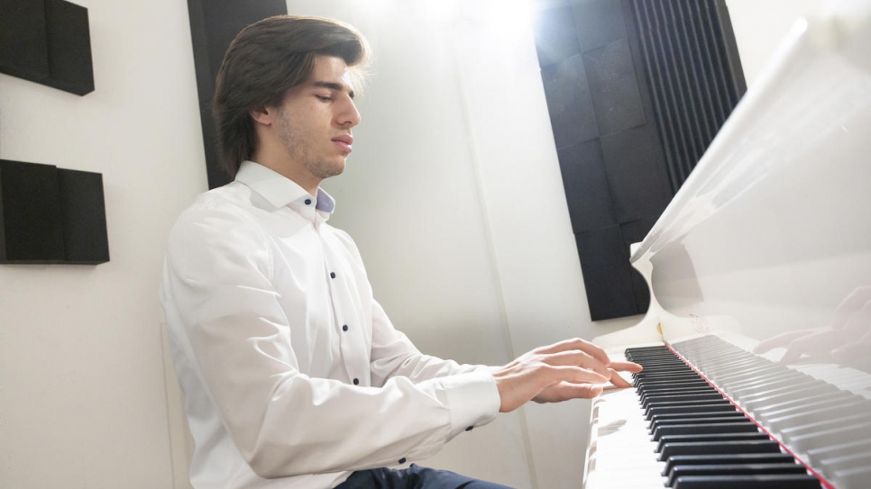 Le pianiste syrien autodidacte Hani Abo Harbbah Alnaeb, 19 ans, répète un morceau de piano à Vienne pour préparer un atelier de musique auquel participeront le violoncelliste Yo-Yo Ma et le Secrétaire général des Nations Unies. Normalement, il pratique de nuit à son domicile sur un clavier électronique. 