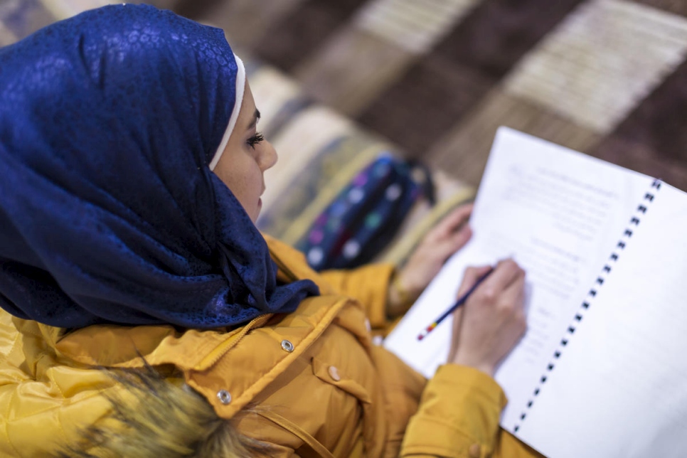 Fidaa, boursière syrienne du programme DAFI, prend des notes pendant un cours de littérature arabe dans la plaine de la Bekaa, au Liban, en mars 2019. 