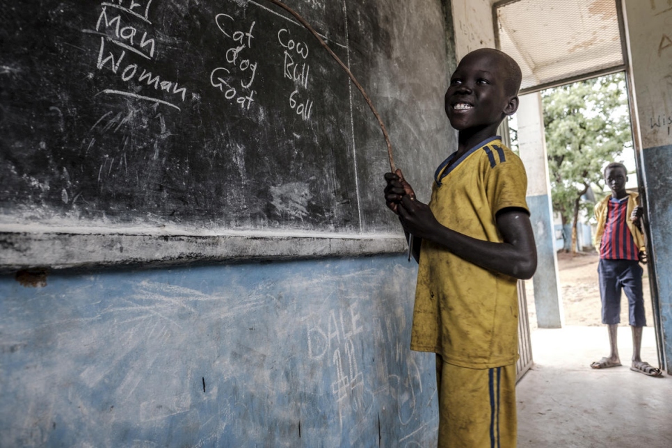 طفل لاجئ من جنوب السودان يبتسم وهو يظهر ما تعلمه في مدرسة جيوي للاجئين في غامبيلا، إثيوبيا. 