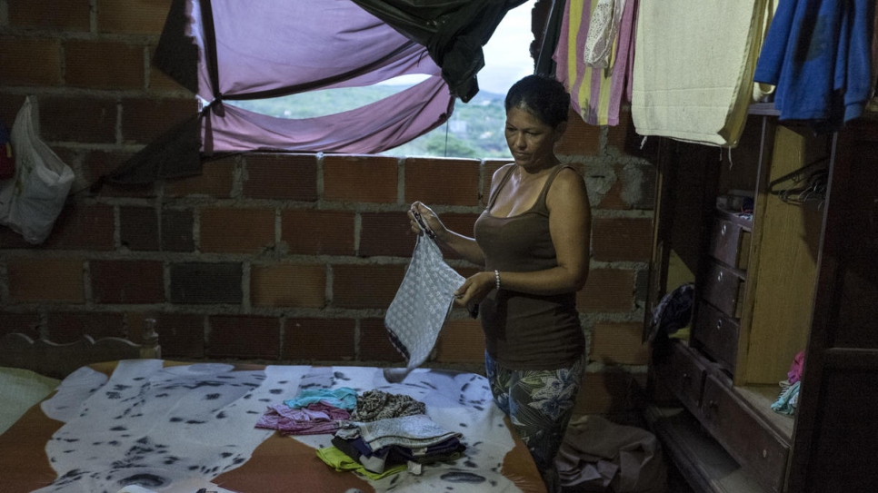 Andreina Diaz from Venezuela folds clothes in Graciela Sanchez's home in Las Delicias, Cúcuta, Colombia. 