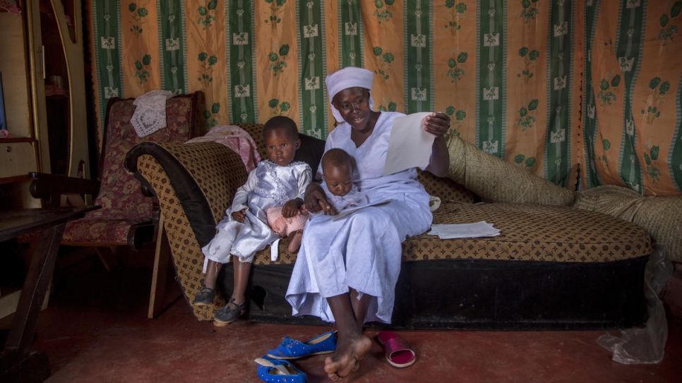 Emma sits at home with her two youngest children and their new birth certificates. 