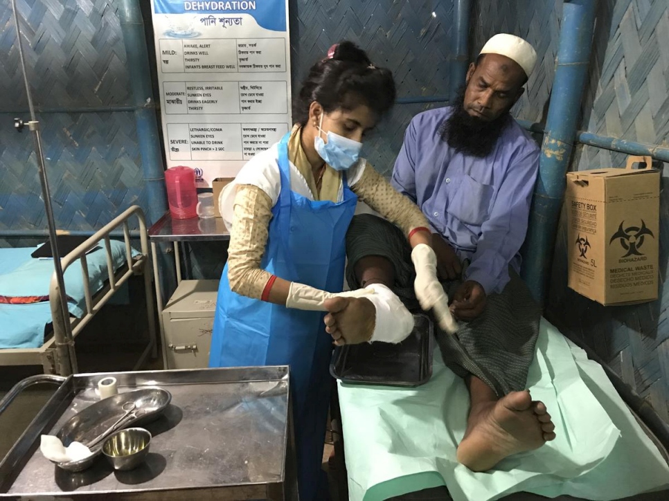 تعالج سرمين أكتار ساتي، الممرضة التي تعمل في عيادة على مدار الساعة في كوتوبالونغ، أحد المرضى الذي ما زال يعاني من آثار العنف التي ألمت به لدى فراره من ميانمار في عام 2017. 