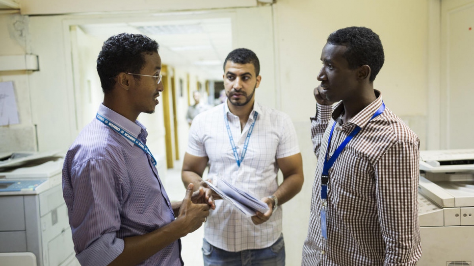 Guled (left) oversees a team of two dozen other interpreters as part of his job.