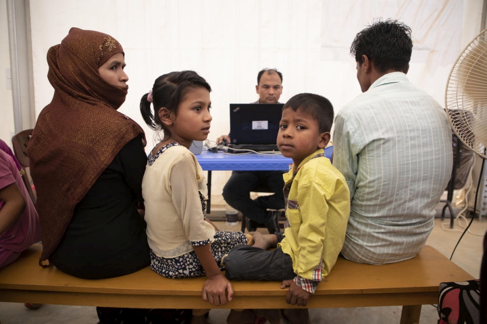 Une famille de réfugiés rohingyas est interrogée par un employé du HCR en charge de l'enregistrement au camp de réfugiés de Kutupalong, au Bangladesh.  