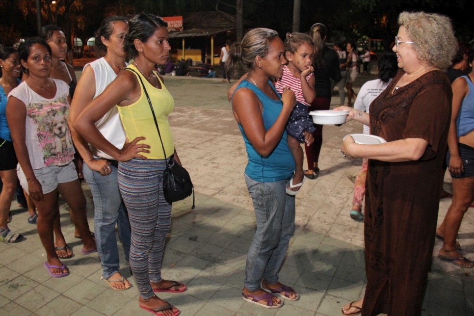 آنا لوسيولا فرانكو (يمين) تقدم المساعدات الغذائية للفنزويليين الذين يعيشون في خيام في ساحة سيمون بوليفار، بوا فيستا، البرازيل. 