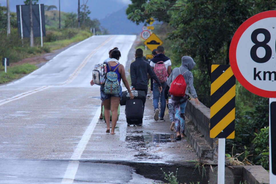 فنزويليون يسيرون من باكايراما، البرازيل، إلى بوا فيستا، عاصمة ولاية رورايما الحدودية. الأشخاص الذين لا يستطيعون تأمين تكلفة النقل العام، يقومون بالرحلة سيراً على الأقدام لمسافة تخطى 200 كلم.