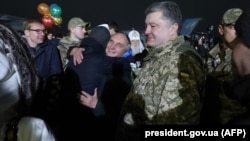 Ukranian President Petro Poroshenko (right) looks on during meetings between former prisoners and relatives at a military air base in Kyiv on December 27.