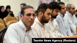 Vahid Mazloumin (left) appears in court in Tehran on charges of manipulating the currency market on September 8.