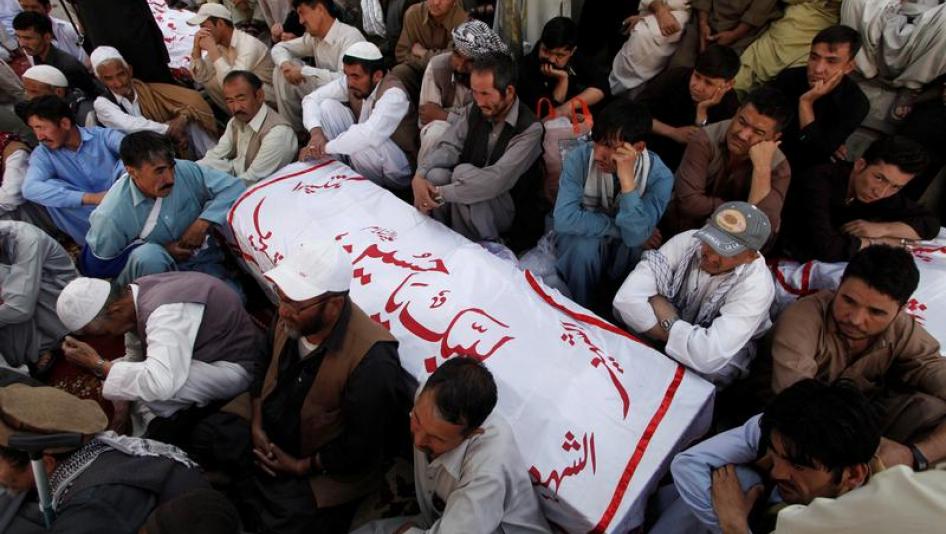 Shi'ite Muslim men from Pakistan's ethnic Hazara minority mourn around the coffins of their relatives, who were killed in a shooting attack, in Quetta, Pakistan October 9, 2017.