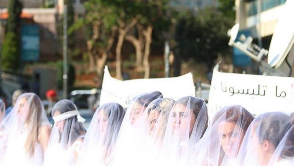 Demonstration outside Lebanon's Parliament on December 6, 2016, with women in white dresses and wrapped in bandages, calling for the repeal of article 522 of the penal code.