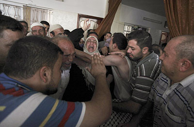 The mother of Hamid Shihab, a Palestinian media worker killed in Wednesday's airstrike, mourns during his funeral.(Reuters/Ashraf Amrah)