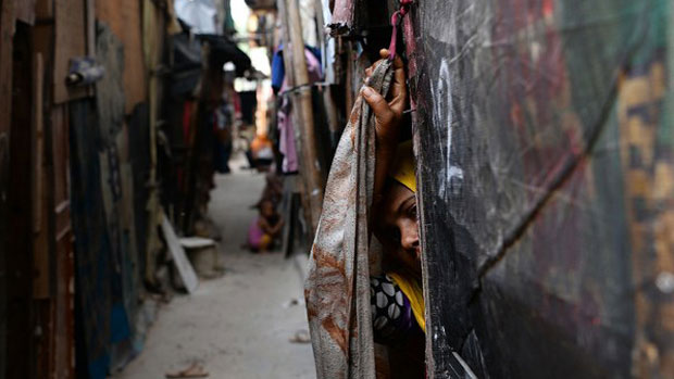 A Rohingya refugee peeps out from her makeshift shelter in New Delhi, Sept. 17, 2017.