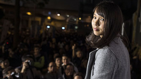 Pro-democracy activist Agnes Chow stands in front of the media during a protest outside the headquarters of the Hong Kong government in Hong Kong, Jan. 28, 2018.